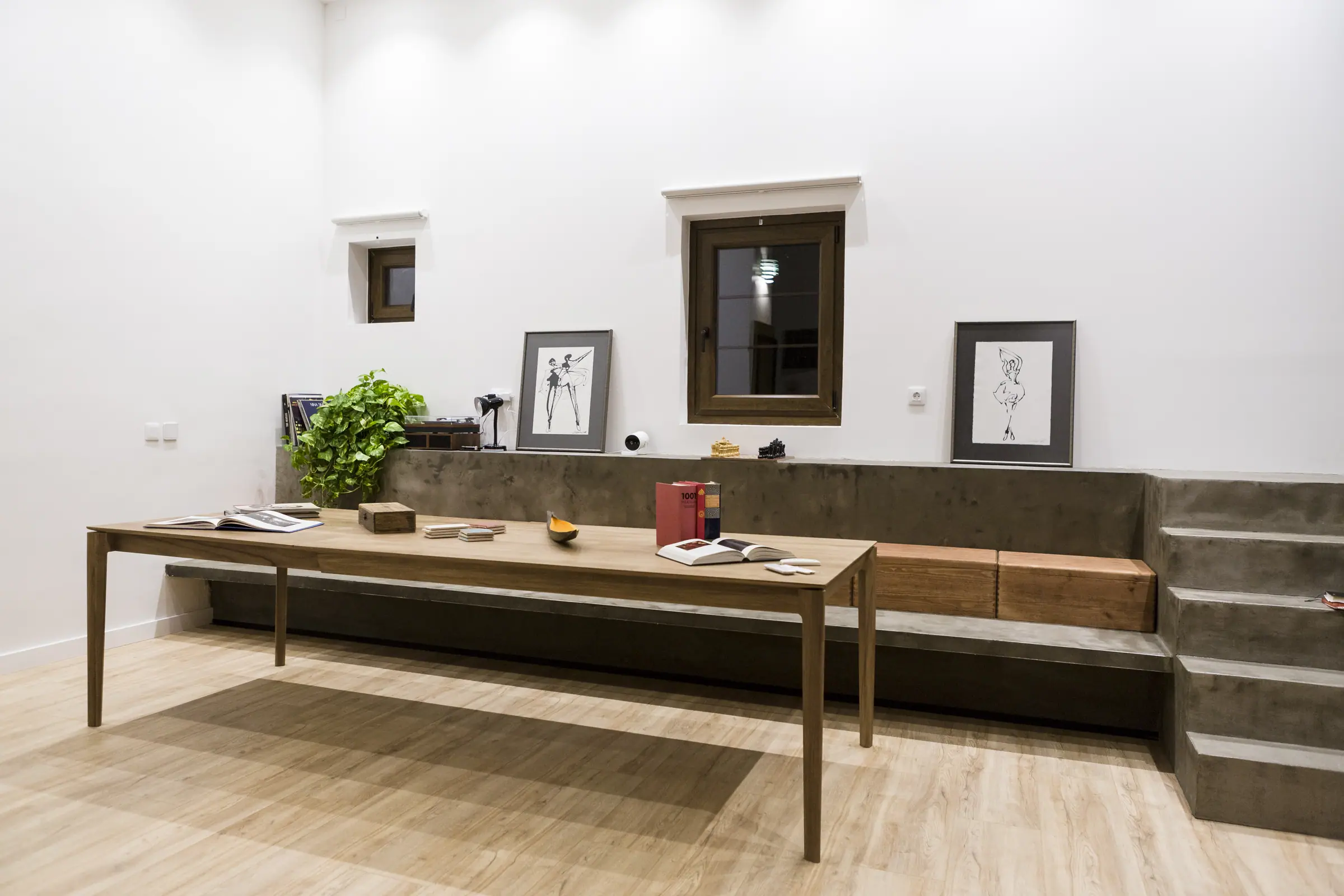 La sala con la mesa larga, el banco corrido y cuadros en la pared